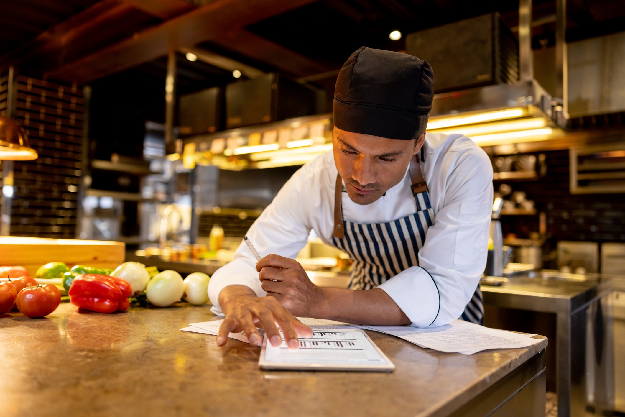 Cook working at a restaurant and looking at a recipe online
